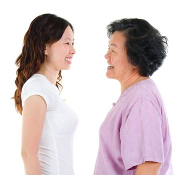 Ageing concept. Asian senior mother and adult daughter face to face, profile side view smiling isolated on white background.