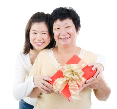 Asian parent and adult offpring holding a gift box smiling, isolated on white background.
