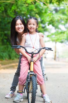 Asian parent and child riding a bike