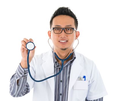 Southeast Asian medical doctor with stethoscope in hand, standing on white background