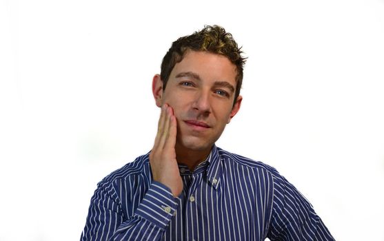 Handsome young man applies moisturizer, shaving or tanning cream on his face