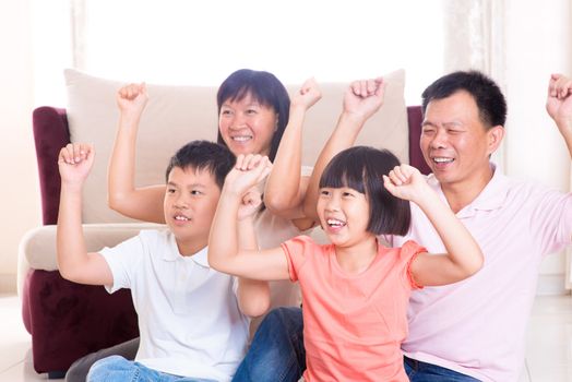 Asian family at home. Portrait of happy parents and children playing game arms raised together at home.