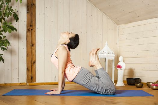 An image of a pretty woman doing yoga at home - Urdhva Mukha Shvanasana