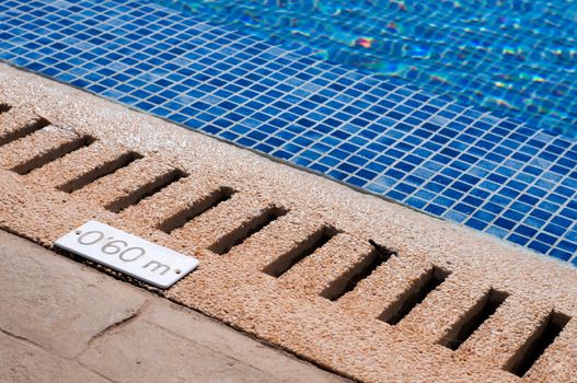 Blue swimming pool and depth indicator, summer