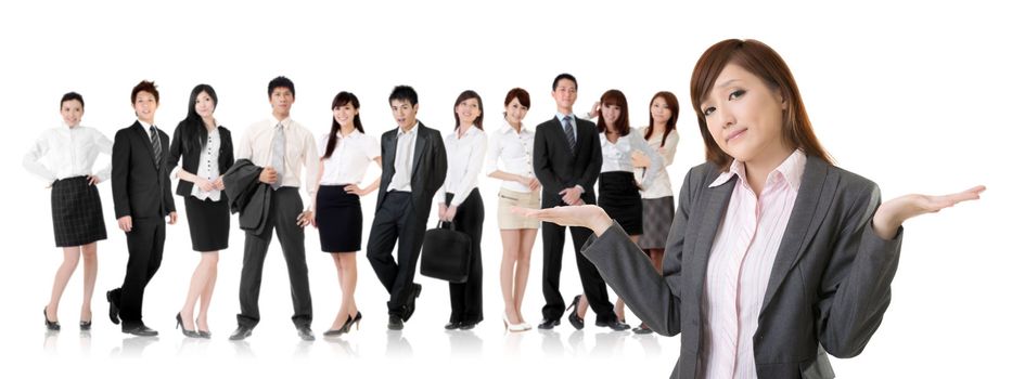 Helpless young business woman shrugs her shoulders in front of her team on white background.