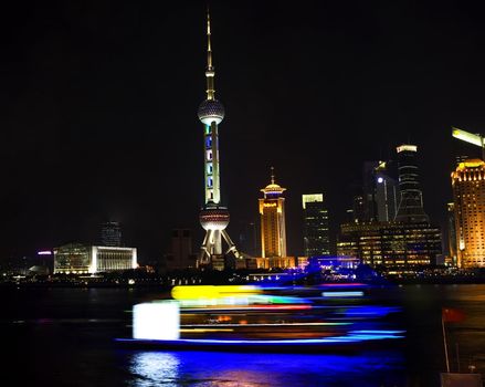 Pudong TV Tower Hotels Shanghai China at Night with Tour Boats in front  Trademarks removed.