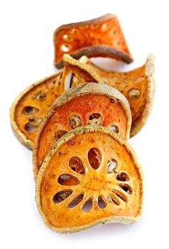 Slices of dried bael fruit on white background