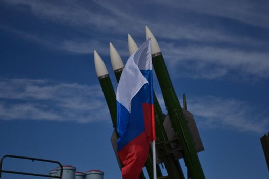 Waving Rusian flag over the rockets and blue sky