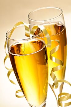 Two full champagne flutes with sparkling wine and ribbon