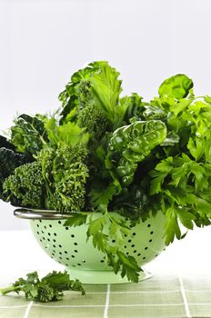 Dark green leafy fresh vegetables in metal colander