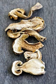 Dried sliced porcini mushrooms against wood background