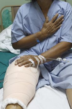 Knee replacement surgery after operation patient senior woman (60s) on the bed in hospital