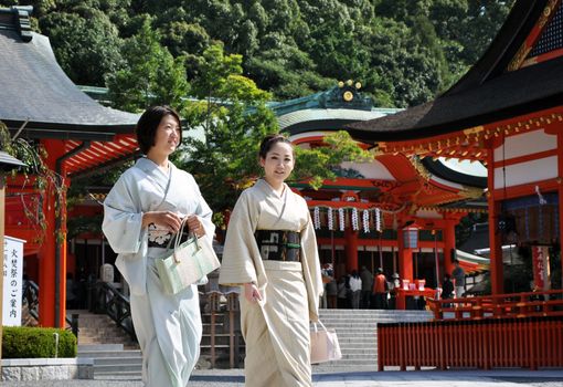 KYOTO, JAPAN - OCT 23 2012: Japanese girls at Fushimi Inari Shrine on October 23 2012. The shrine is famous for its torii gates walkway that lead to the top of the mountain.