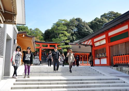 KYOTO, JAPAN - OCT 23 2012: A tourist at Fushimi Inari Shrine on October 23 2012. The shrine is famous for its torii gates walkway that lead to the top of the mountain. 