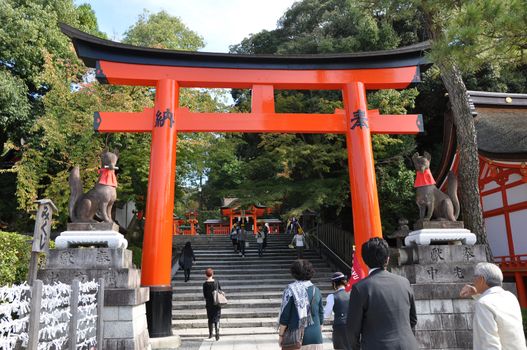 KYOTO, JAPAN - OCT 23 2012: A tourist at Fushimi Inari Shrine on October 23 2012. The shrine is famous for its torii gates walkway that lead to the top of the mountain. 