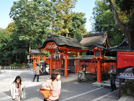 KYOTO, JAPAN - OCT 23 2012: A tourist at Fushimi Inari Shrine on October 23 2012. The shrine is famous for its torii gates walkway that lead to the top of the mountain.