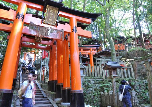 KYOTO, JAPAN - OCT 23 2012: A tourist at Fushimi Inari Shrine on October 23 2012. The shrine is famous for its torii gates walkway that lead to the top of the mountain.