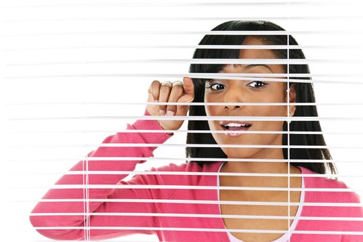 Young black woman looking through horizontal venetian blinds