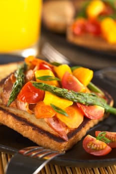 Baked asparagus, mango, tomato, carrot and bacon sandwich on wholewheat toast bread (Selective Focus, Focus on the asparagus tips in the front)