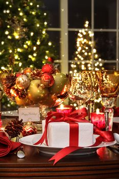 Festive dinner table setting with red ribbon gift