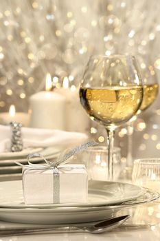 Festive table setting with silver ribbon gift on plate