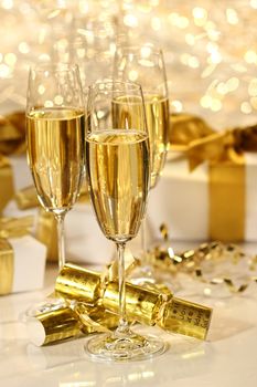 Glass of champagne against gold sparkle background 