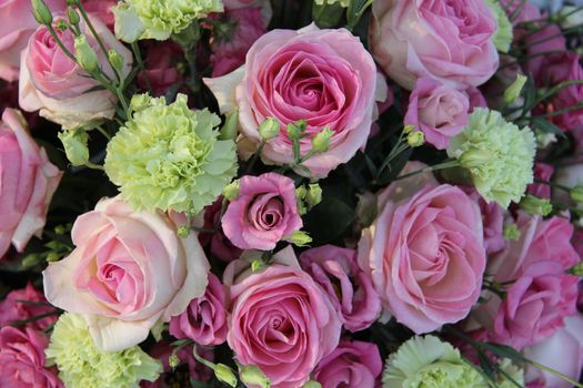Pink roses and green white carnations in a bridal flower arrangement