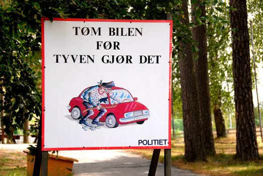 Norwegian sign with txt: Empty your car before the theaf do it. Norway 2008. Selectiv focus.