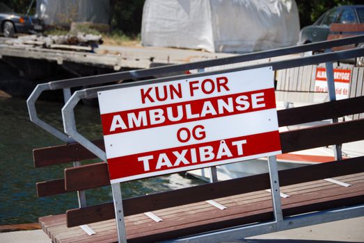 Ambulance and TaxiBoat Sign on Harbour. 
Norway 2008.
