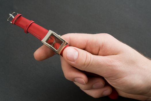 Hand with red watch on a black white background