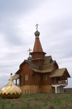 Wooden chapel with golden dome on the ground