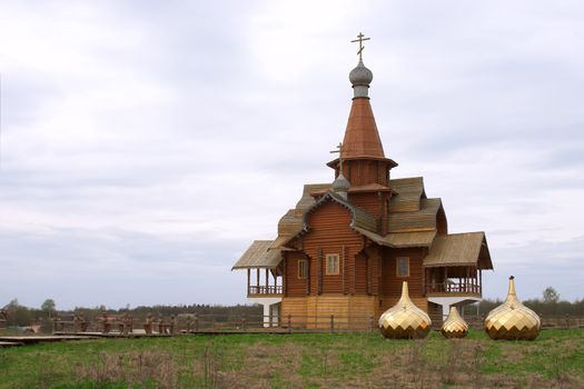 Three golden dome on the ground near wooden chapel