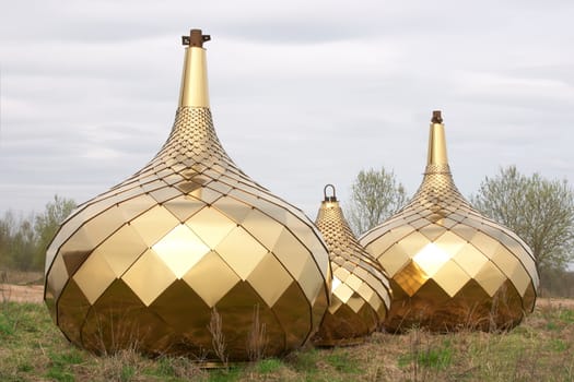 Three golden dome on the ground over blue sky