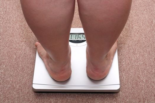 women legs with overweight standing on bathroom scales