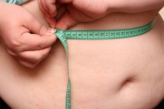 overweight women measure her stomach