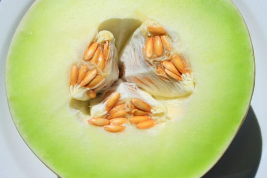 Close up of a honeydew melon on a plate.
