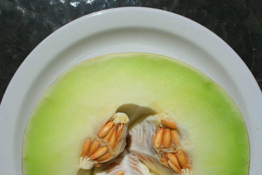 Close up of a honeydew melon on a plate.

