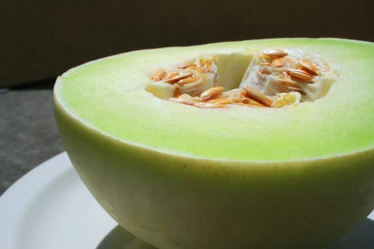 Close up of a honeydew melon on a plate.
