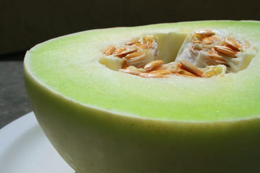 Close up of a honeydew melon on a plate.
