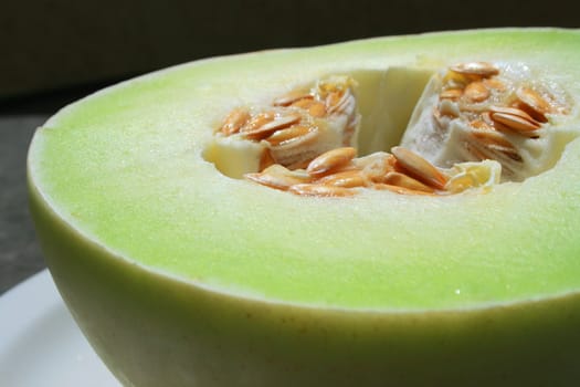 Close up of a honeydew melon on a plate.
