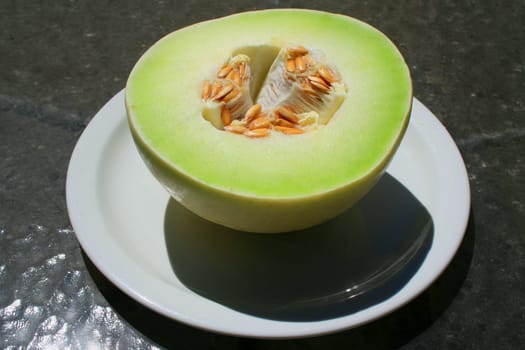 Close up of a honeydew melon on a plate.
