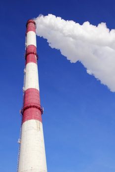 Smoking pipes of thermal power plant against blue sky
