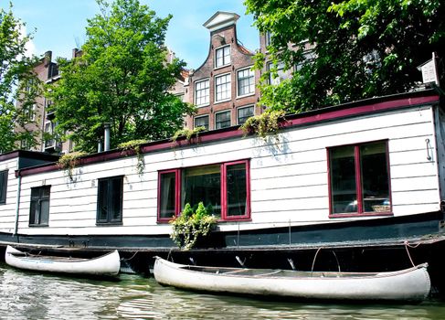 Floating house with boats in Amsterdam