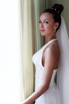 The beautiful bride at a window. Natural illumination