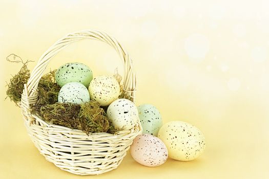 Beautiful Easter egg in a basket against a yellow background with copy space. 

