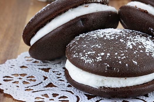 Macro image of three whoopie pies or moon pies with powdered sugar. Shallow depth of field.