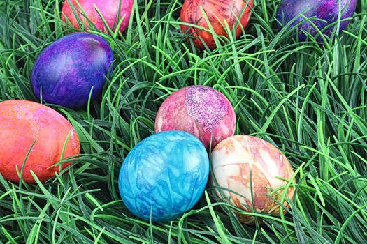 Hand painted tie dyed Easter eggs in the grass. Extreme shallow DOF.
