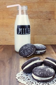 Whoopie pies or moon pies with a bottle of milk. Shallow depth of field.