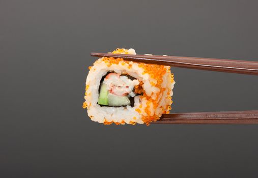 Sushi with chopsticks isolated over gray background