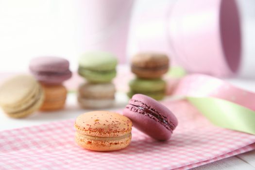 Macaroons with napkin on wooden table